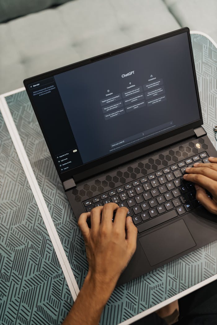 creative Person typing on a laptop with ChatGPT displayed, showcasing modern technology use.