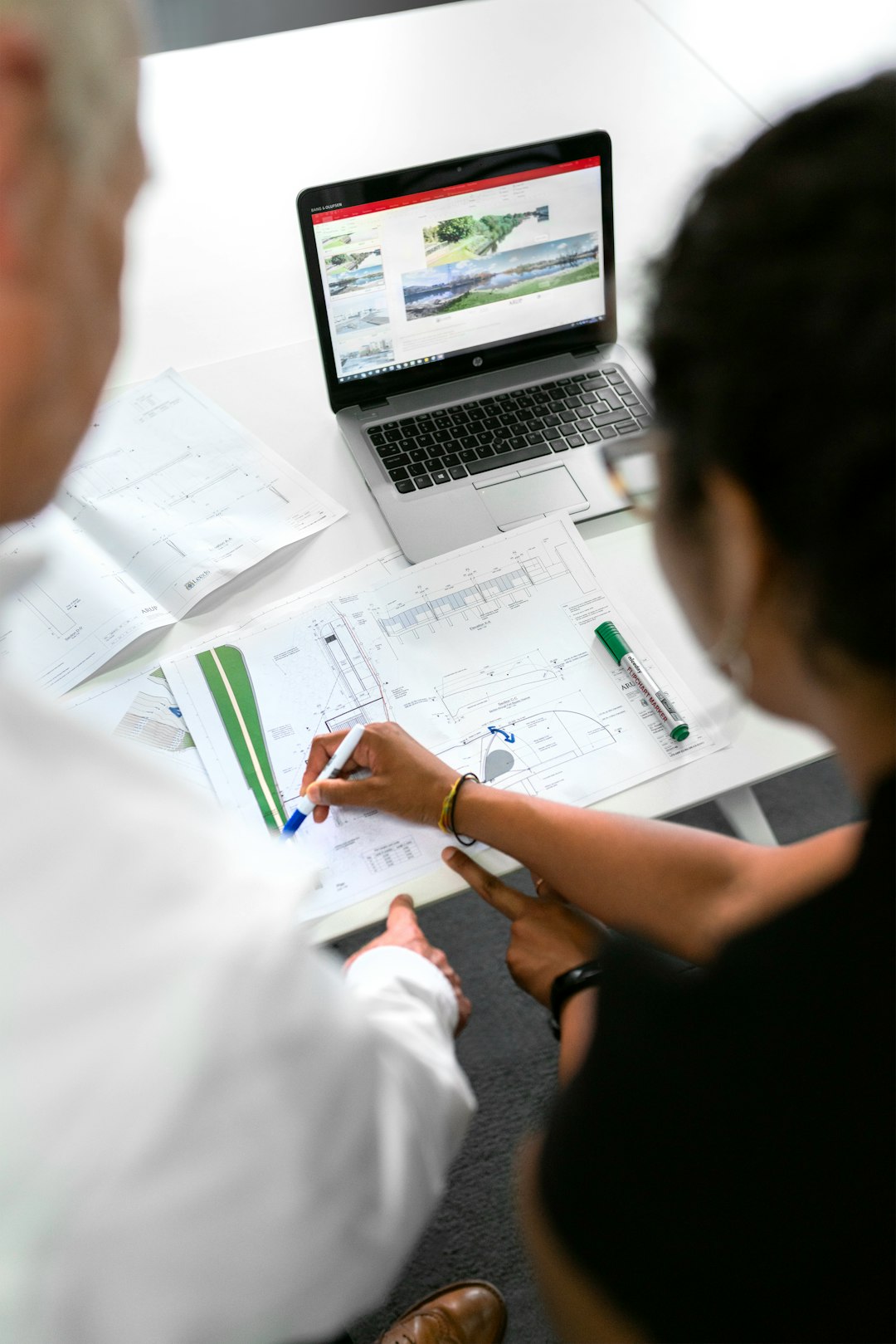 creative-01 Female civil engineer discusses flood risk management plans with colleague